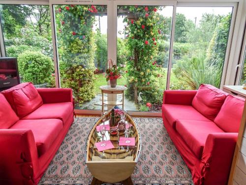 un salon avec deux canapés rouges et une table dans l'établissement Villa Ty Patrick by Interhome, à Kerguillaouet