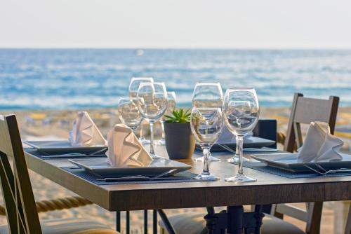 a table with wine glasses on the beach at Alaaddin Beach Hotel - Adult Only in Alanya