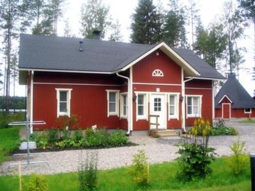 Holiday Home Kurrela by Interhome في Toiviaiskylä: منزل احمر بسقف اسود