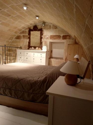 una camera con letto e tavolo con lampada di Casa Masiello La casa tipica dei Sassi di Matera a Matera