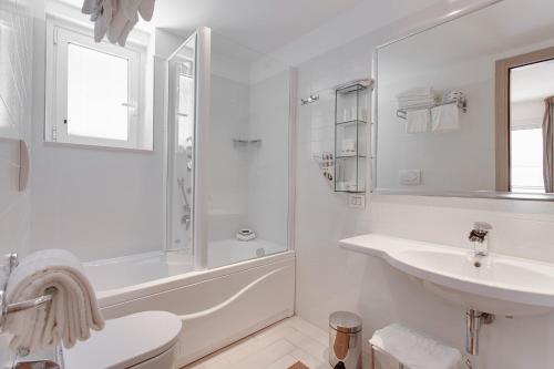 a white bathroom with a sink and a toilet at Kontiki in Milano Marittima