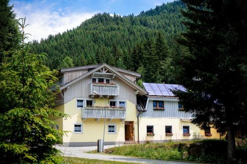 una grande casa bianca con balcone e alberi di Haus Alpengluehn a Iselsberg
