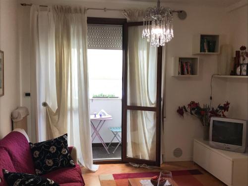 un soggiorno con divano e porta scorrevole in vetro di Cosy Flat a Treviso