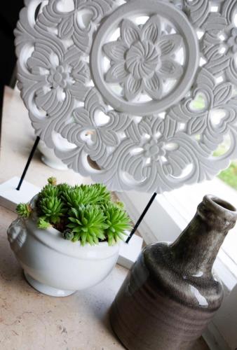 a white vase and a vase with plants in it at Hacienda Rooms in Friedrichshafen