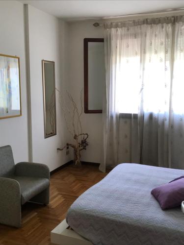 una camera con un letto e una sedia e una finestra di Cosy Flat a Treviso