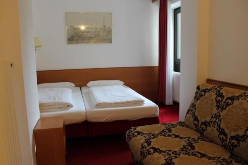 a hotel room with two beds and a chair at Hotel Montree in Munich