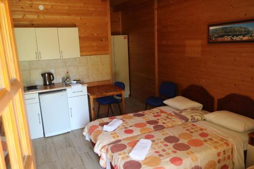 una habitación con 2 camas y una cocina en una cabaña en Guest House Jadran Pol, en Petrovac na Moru