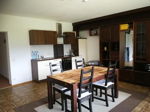 a kitchen with a wooden table and chairs at Nibbie's Happy Apartment in Schiefling am See