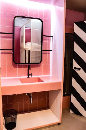a bathroom with a sink and a mirror at Artsy Vitoria Hostel in Vitória