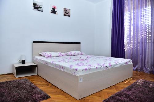 a bedroom with a bed with pink sheets and pillows at Vila Arjana in Orşova
