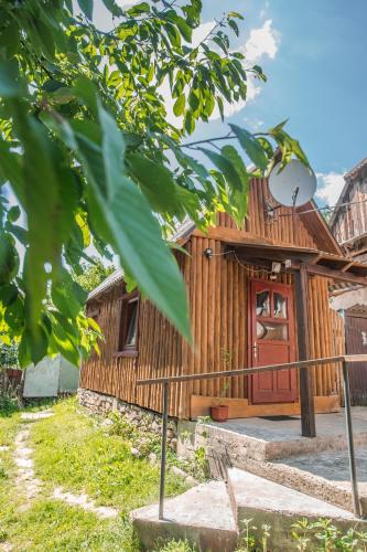 a wooden house with a red door at Садиба над потоком in Lumshory