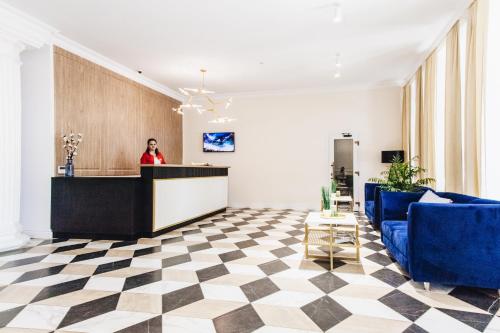 a woman standing at a counter in a lobby at Готель Континент Миколаїв in Mykolaiv