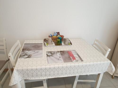 une table blanche avec deux chaises et une plaque de cuisson dans l'établissement Studio, à Corte