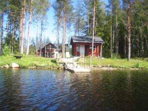 a cabin on the shore of a body of water at Holiday Home Kurrela by Interhome in Toiviaiskylä