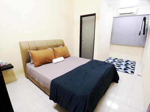 a bedroom with a bed with a blue blanket at Eisya Guest House With Pool in Arau