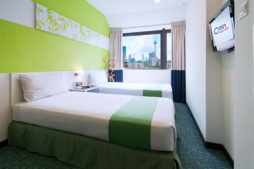 um quarto de hotel com duas camas e uma televisão em Citin Hotel Masjid Jamek by Compass Hospitality em Kuala Lumpur