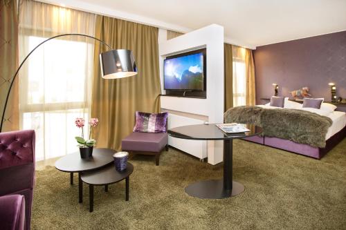 a hotel room with a bed and a tv at Park Villa Hotel in Wuppertal