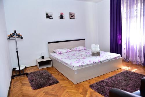 a bedroom with a bed and two rugs at Vila Arjana in Orşova