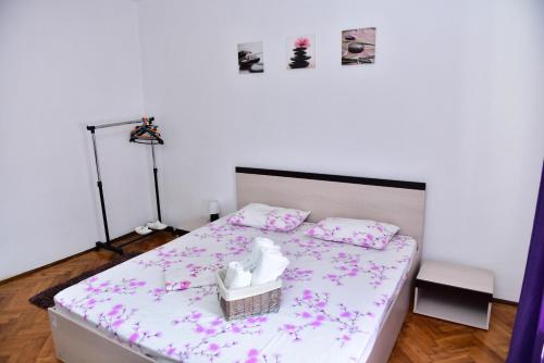 a bedroom with a bed with pink flowers on it at Vila Arjana in Orşova