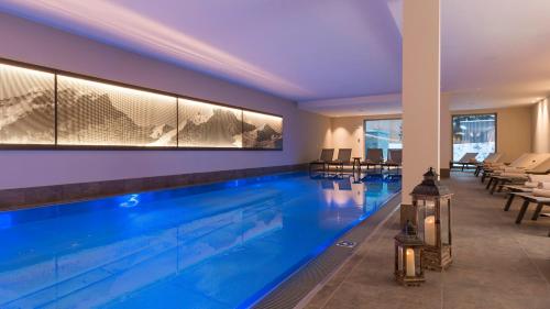 a large swimming pool in a hotel room with a swimming pool at AMERON Davos Swiss Mountain Resort in Davos