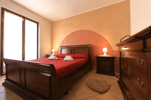 a bedroom with a bed with a red bedspread at Residenza Franca in Valeggio sul Mincio