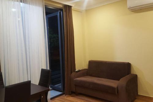 a living room with a couch and a table and a window at Апартаменты у моря от Ирины in K'obulet'i