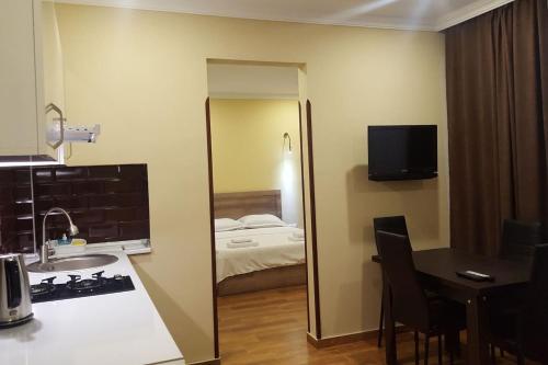 a bathroom with a sink and a room with a bed at Апартаменты у моря от Ирины in K'obulet'i