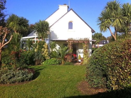 una casa bianca con palme e un cortile di Villa Ty Patrick by Interhome a Kerguillaouet