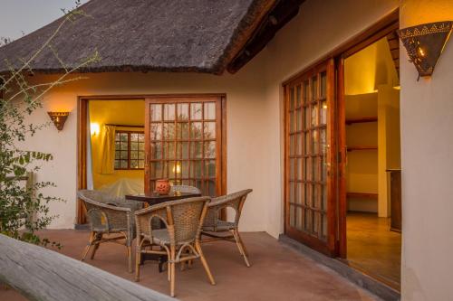 a patio with a table and chairs in a house at Mbizi Bush Lodge in Grietjie Nature Reserve