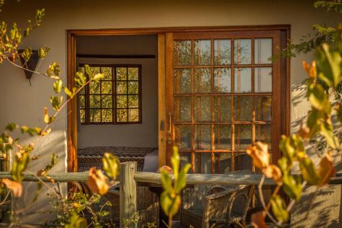 a wooden door with glass windows and a fence at Mbizi Bush Lodge in Grietjie Nature Reserve