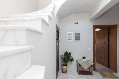 a hallway with white walls and a door and a table at Anastellar in Kissamos