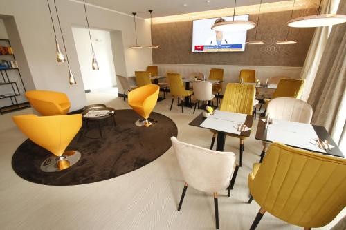 a dining room with tables and chairs and a tv at Amelie No 1 Hotel & Appartements in Landau in der Pfalz