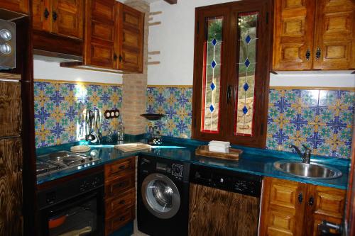 a kitchen with a sink and a washing machine at Casa Rural Ermita Santa Maria de la Sierra in Arroyo Frio