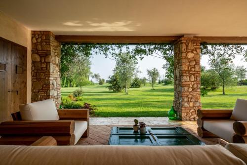 a living room with a large window with a tub at Creative Design House Golf & SPA in Pozzolengo
