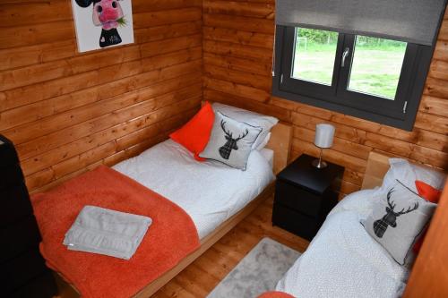 um pequeno quarto com 2 camas e uma janela em Long Wood Lodges em Knighton