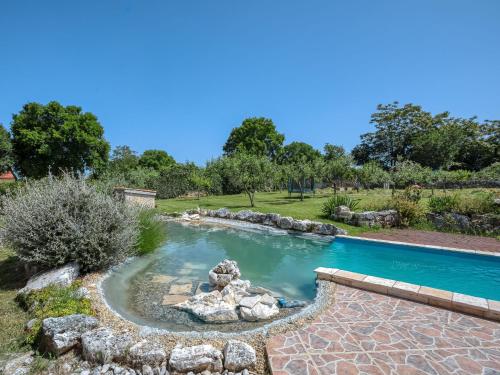 una piscina in un cortile con rocce e laghetto di Holiday Home Mario 1 by Interhome a Hreljići