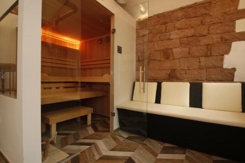 a bathroom with a tub and a stone wall at Amelie No 1 Hotel & Appartements in Landau in der Pfalz