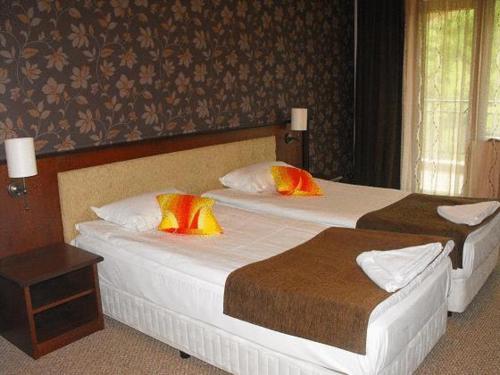 Dos camas en una habitación de hotel con dos en Hotel Park, en Karnobat