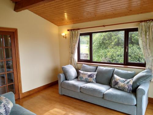a living room with a couch and a window at Tyddyn Crwn Country-House Apartments in Beaumaris
