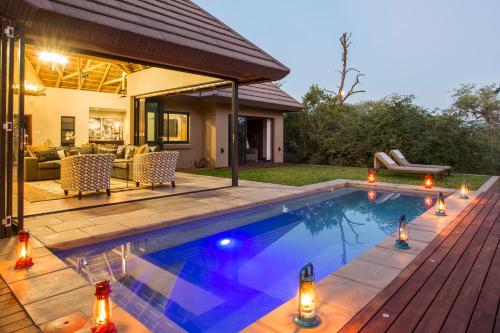 a swimming pool in the backyard of a house at Moya Safari Villa in Hoedspruit