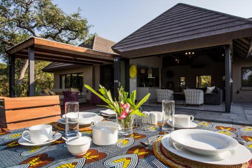 a table with plates and dishes on a patio at Moya Safari Villa in Hoedspruit