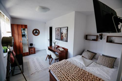 a bedroom with a bed and a desk with a camera at Siedlisko Vincent in Szydłów