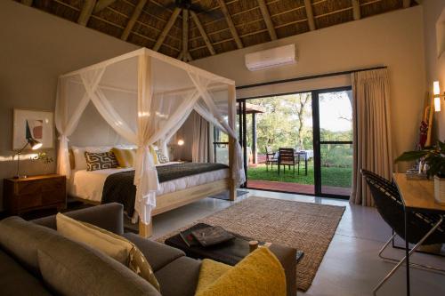 a bedroom with a bed with a canopy at Moya Safari Villa in Hoedspruit