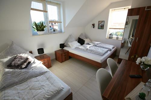 a bedroom with two beds and a table and two windows at Siedlisko Vincent in Szydłów