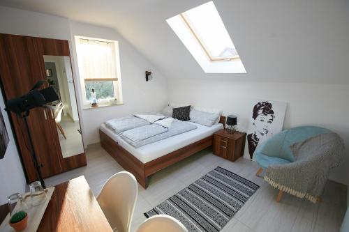 a small bedroom with a bed and a chair at Siedlisko Vincent in Szydłów