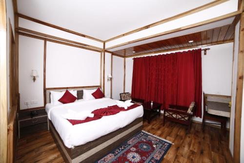 a bedroom with a bed with a red curtain at Buddha Retreat in Ravangla