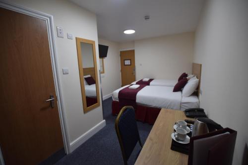 a hotel room with a bed and a table at PremierLux Serviced Apartments in Ilford
