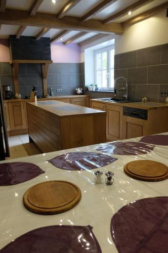 a kitchen with a table with wooden plates on it at Gîte "L'échappée amoureuse et féérique" in Paliseul