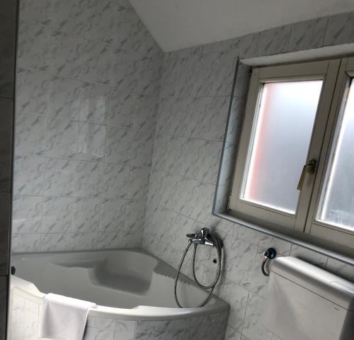 a bathroom with a bath tub and a window at Leo in Niš