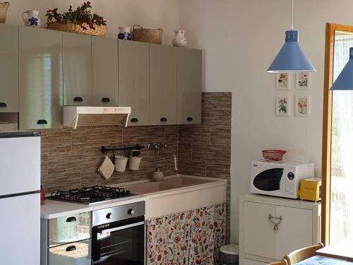 a kitchen with a sink and a stove and a microwave at Casa con vista in Corniolo